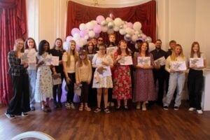 All student winners smiling under a balloon arch