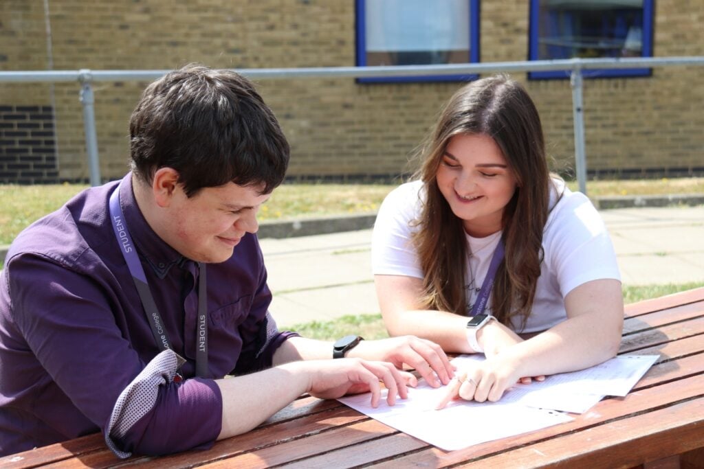students talking together, looking at a paper