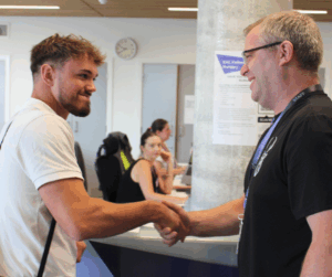 Construction student shaking hands and smiling with Construction lecturer.