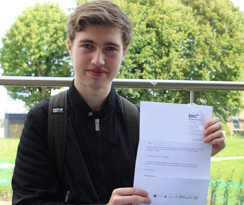 Student looking at the camera with his Level 3 results and smiling.