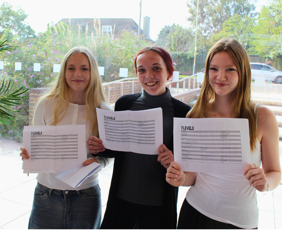 Three Early Year and Education students holding up their passes and smiling at the camera.