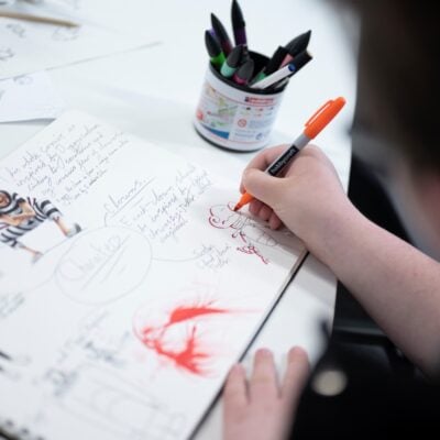 a student illustrates in a notebook