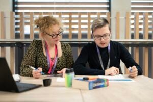 creative students works at a desk with support staff