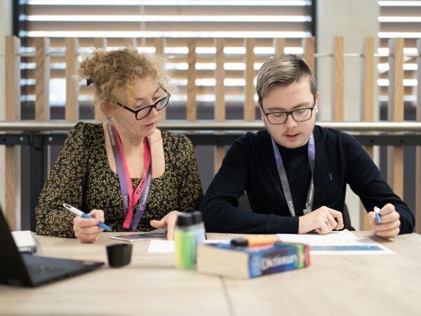 creative students works at a desk with support staff