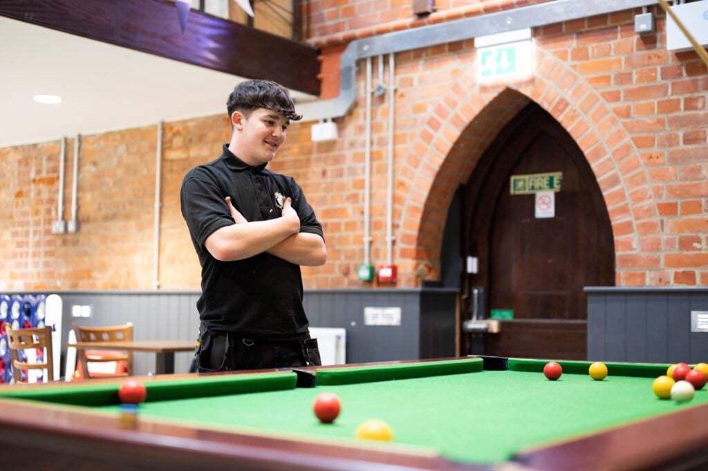 a student at a pool table at college