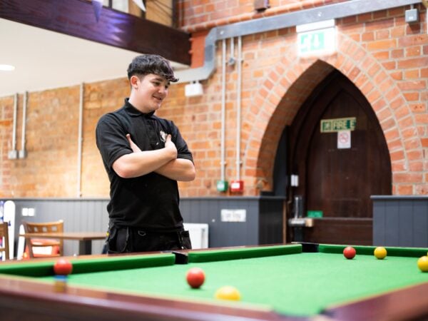 a student at a pool table at college