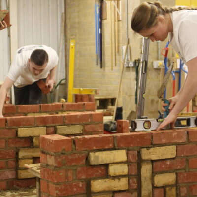 Students building a brick wall for a competition.