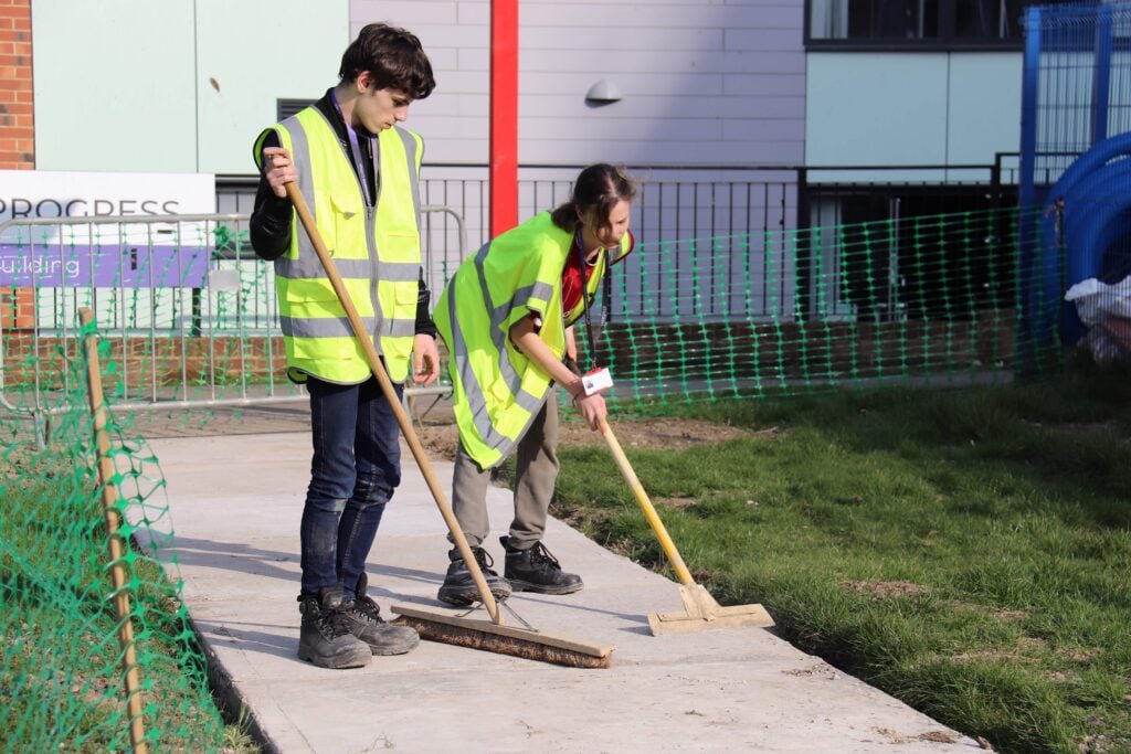 students sweeping a pathway