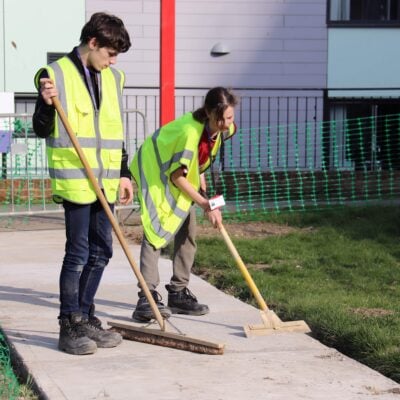 students sweeping a pathway