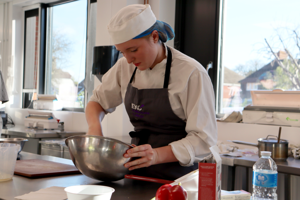 Student in a kitchen whisking