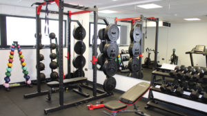 New sport equipment in the gym including Smith machine and free weights.
