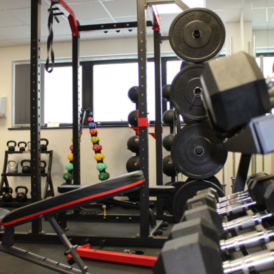 New sport equipment in the gym including Smith machine and free weights.