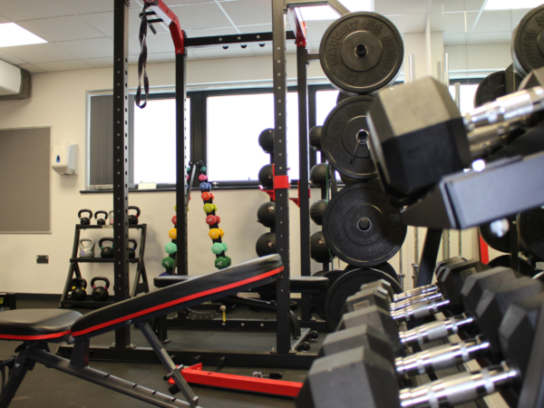 New sport equipment in the gym including Smith machine and free weights.