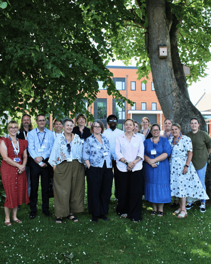 A group photo standing outside under trees in the college grounds. They are all local employers around Kent.