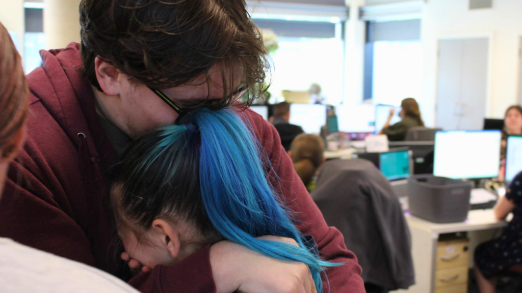 Two student embracing in a hug after receiving good GCSE English results.