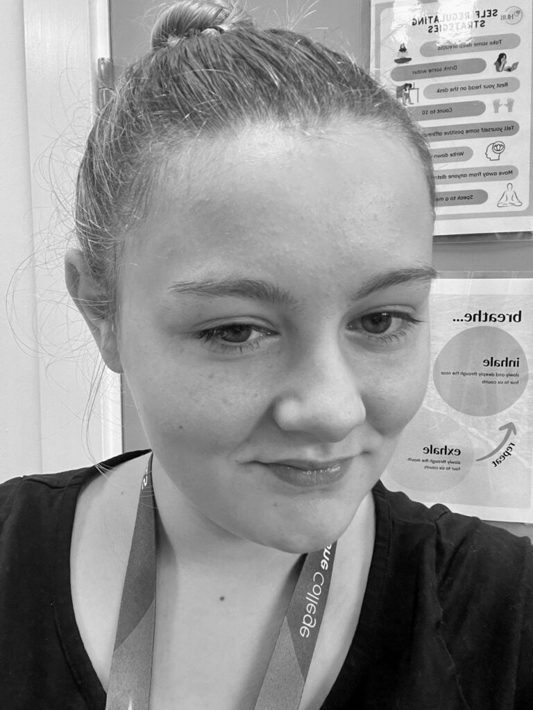 Black and white portrait of student president with her hair slick back looking and smiling at the camera.